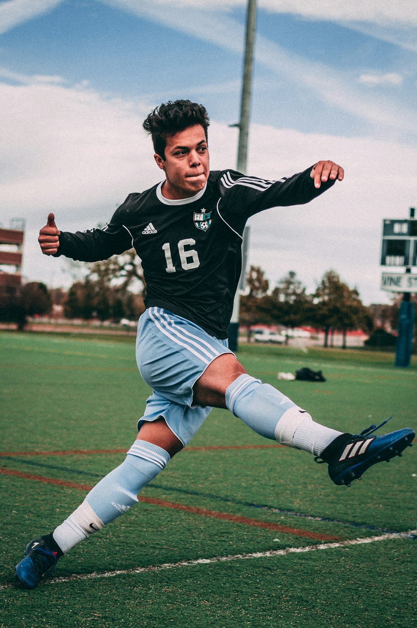 Young footballer striking the ball mid-match